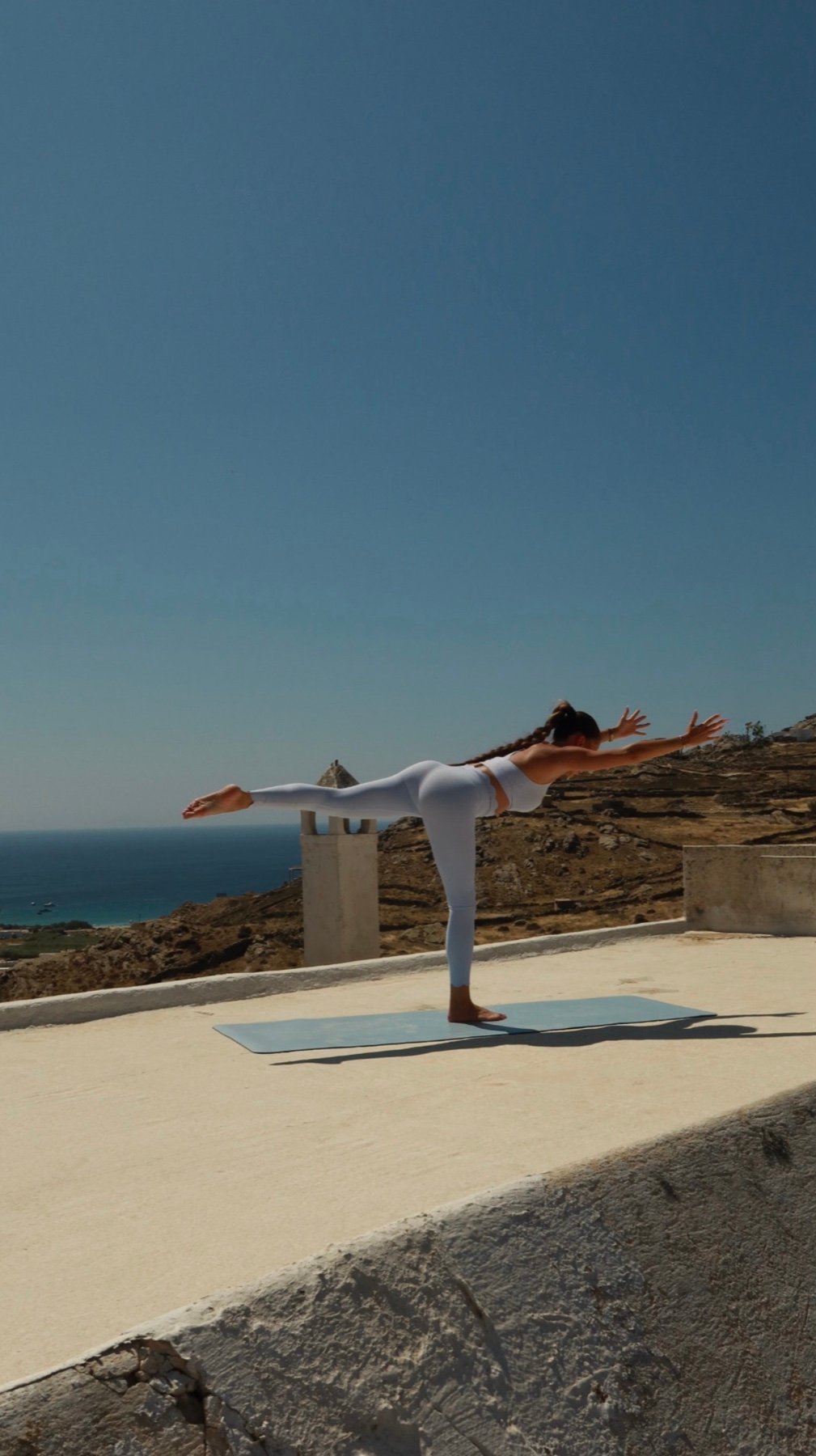 Morning yoga practice on a whitewashed terrace above the sea in Mykonos