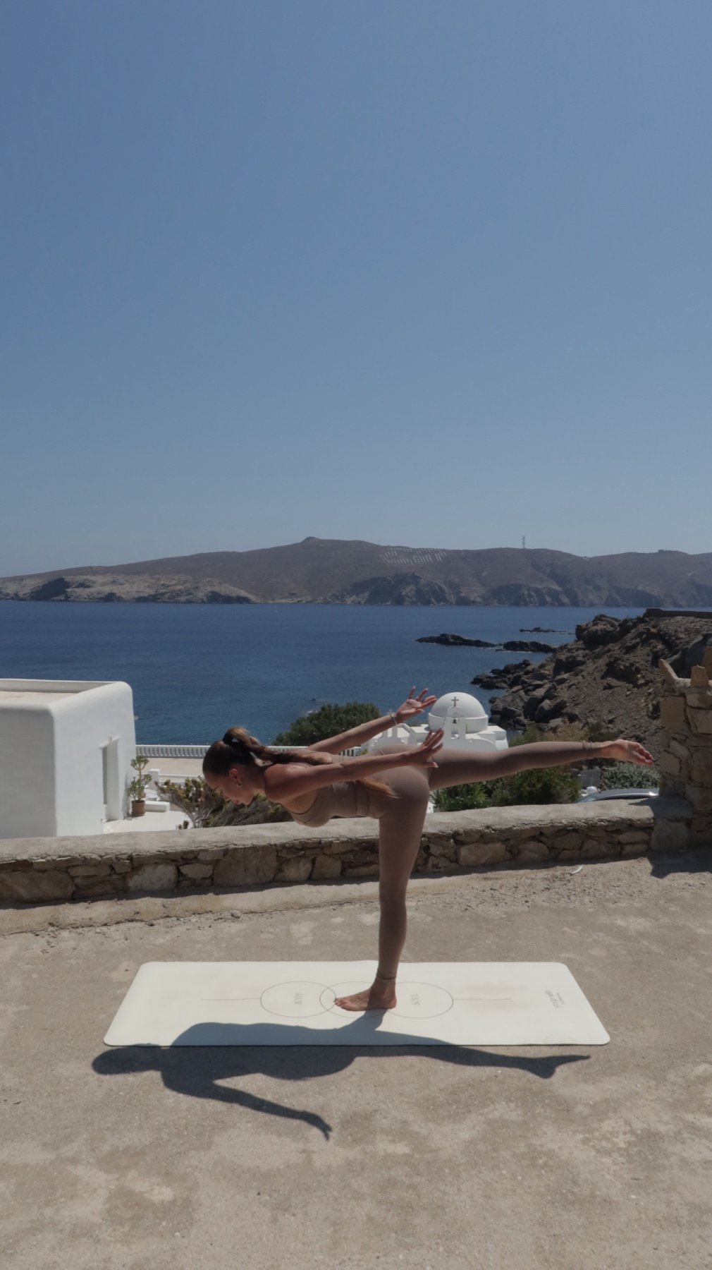 Yoga retreat terrace with a sea view and a white chapel in Mykonos