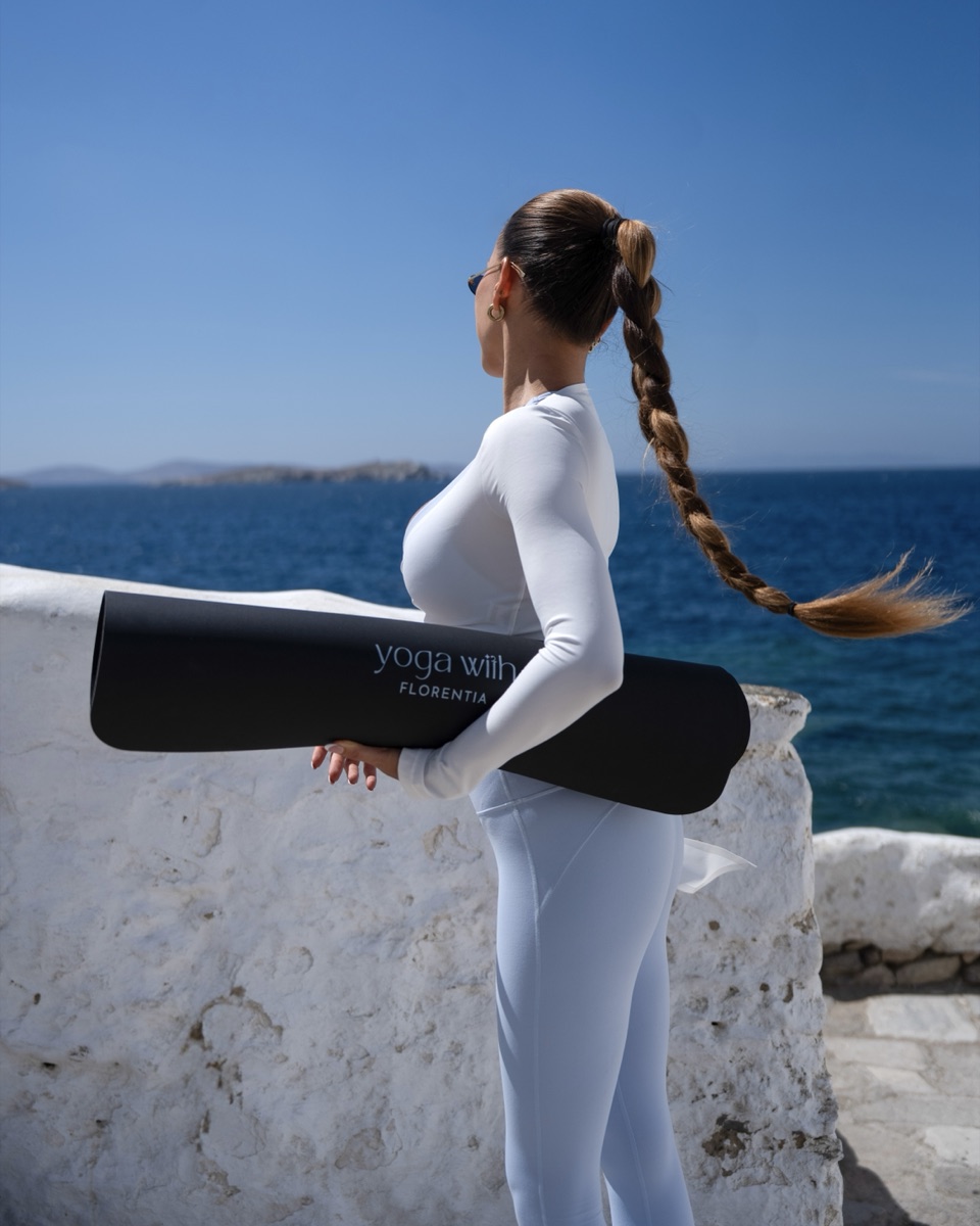 Florentia with her yoga mat by the sea in Mykonos